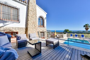 A terrace with wicker furniture, a pool, and a view of the sea. - Villa rental in Moraira, MIMOSA (Moraira)