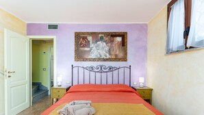 A bedroom with a bed, a painting on the wall, a window with curtains, and a door leading to another room. - Holiday Home 'Gli Amici Di Adry' with Sea View, Wi-Fi and Air Conditioning (Siniscola)