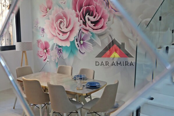 A conference room with a table, chairs, and a floral mural on the wall.