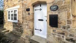 A stone building with a white door, a window, and a sign that reads 'Lakeside Cottage.' - Lake Side Cottage (Wakefield)