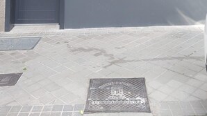 La façade d’un immeuble porte une enseigne indiquant « Hostal Bernabeu II », une porte fermée, une fenêtre avec un volet et un petit appareil de climatisation.