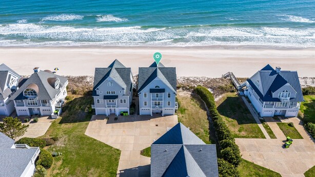 A beachfront property with multiple houses, a clear view of the ocean, and a well-maintained lawn. - Oceanfront | Pet Friendly | Elevator | Hot Tub | Pool Access (North Topsail Beach)
