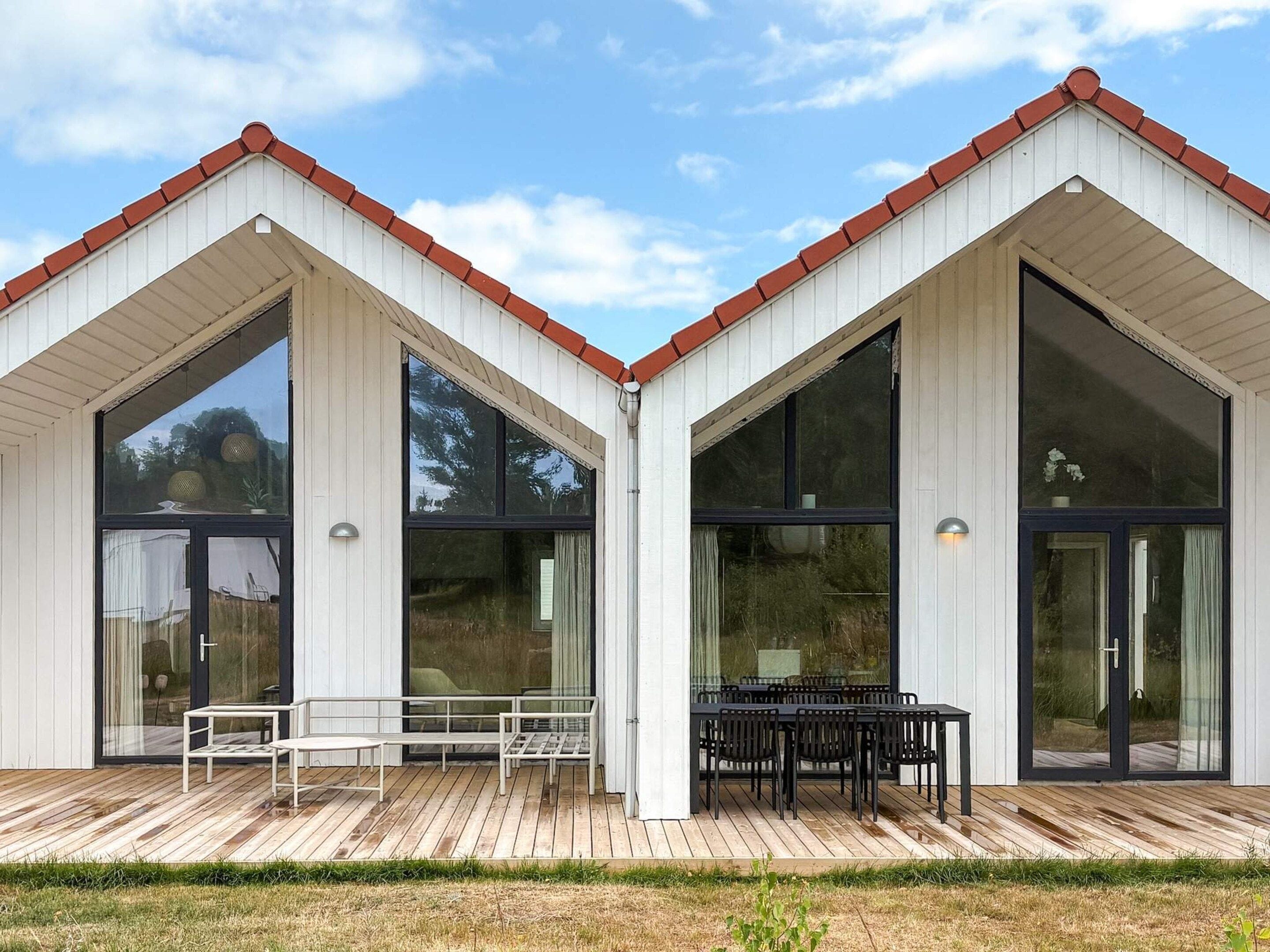 A modern building with large windows and a wooden deck.