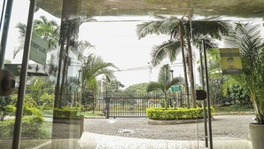 A gated entrance with palm trees and a paved pathway leading to a building. - Exclusive apartment close to Laureles and Provenza (Medellín)