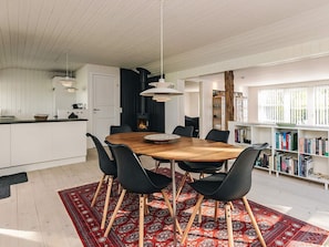 Une cuisine moderne avec un coin repas, une cheminée et une bibliothèque.