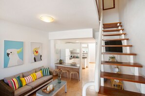 Una sala de estar moderna con un sofá, una mesa de centro y una escalera.
