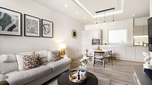 A modern living room with a sofa, coffee table, and artwork on the wall. - 5 Mins Walk to Battersea Park Battersea Retreat (London)
