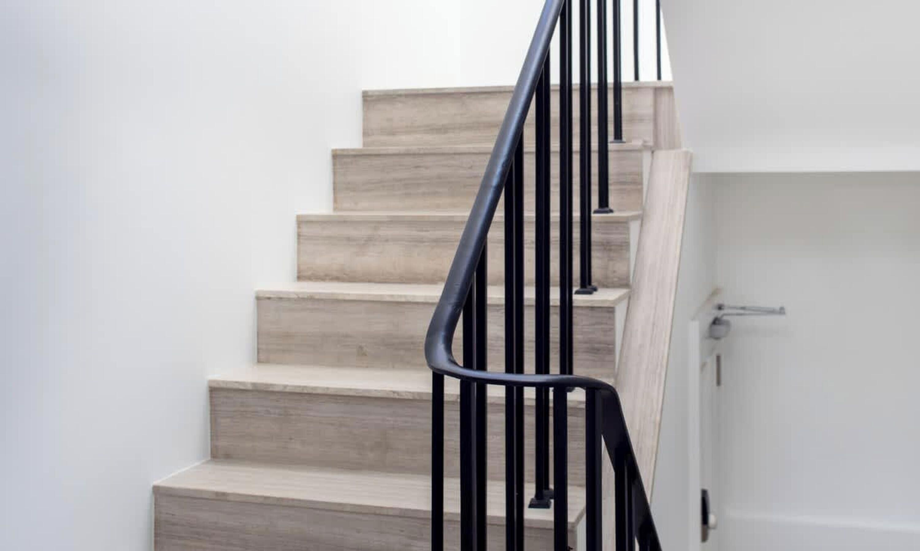 Una escalera con peldaños de madera y barandales de metal negro.