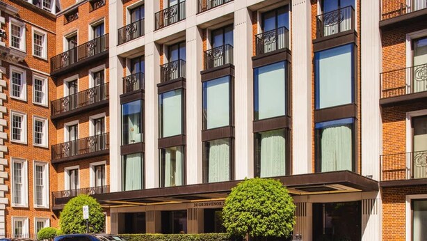 Un hotel de varios pisos con fachada moderna, que cuenta con amplios ventanales y balcones.