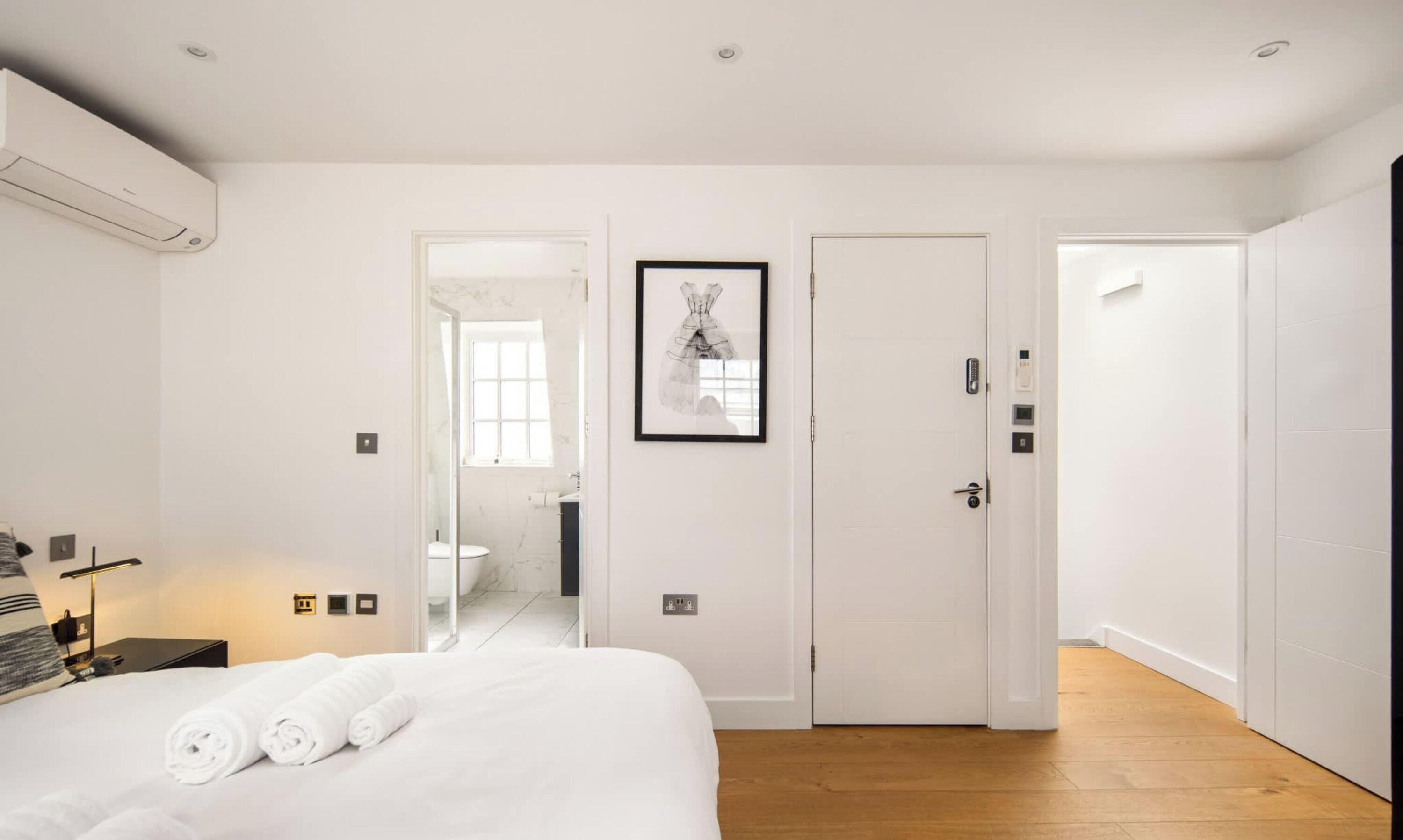 Une chambre d’hôtel avec un lit, une salle de bain et un couloir.