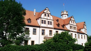 Un grand bâtiment historique doté de nombreuses fenêtres et d’une tour imposante.