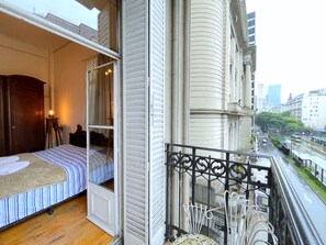 A bedroom with a bed, a nightstand, and a window with curtains. - La Platea de Bs As 2A BIS In front of Palacio Libertad (Buenos Aires)