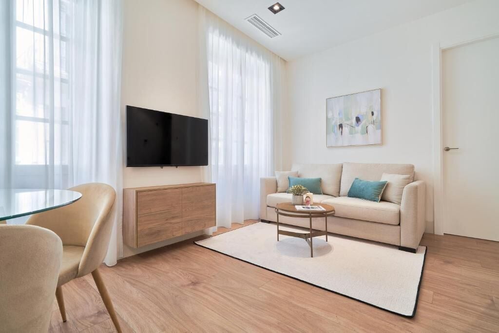 Ein modernes Wohnzimmer mit einer Couch, einem Couchtisch und einem Fernseher.