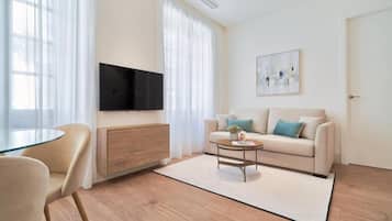 Ein modernes Wohnzimmer mit einer Couch, einem Couchtisch und einem Fernseher.