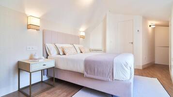 A bedroom with a bed, bedside table, and two wall-mounted light fixtures.