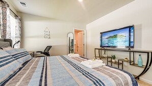 A hotel room with a bed, a TV, a desk, and a bathroom visible through an open door. - Ocean Breeze Escape! (Ocean Isle Beach)