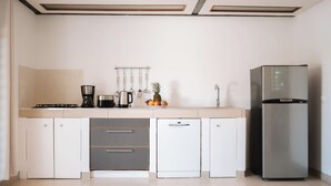 Eine moderne Küche mit Gasherd, Kaffeemaschine, Geschirrspüler und einem Edelstahl-Kühlschrank.
