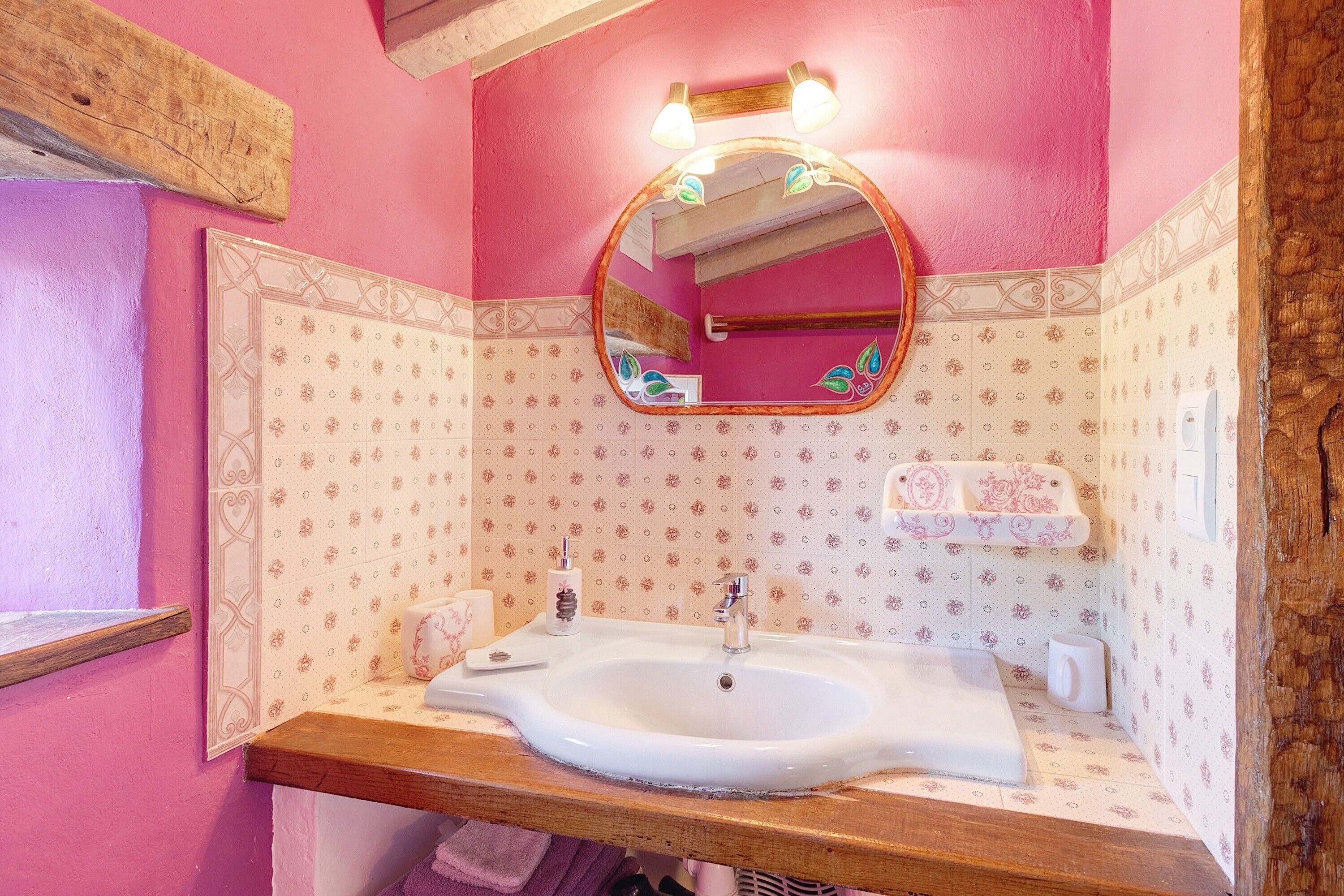 Ein Badezimmer mit Waschbecken, Spiegel und dekorativen Fliesen.