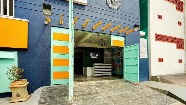 A hotel entrance with a sign reading 'HOTEL' and a reception desk inside.
