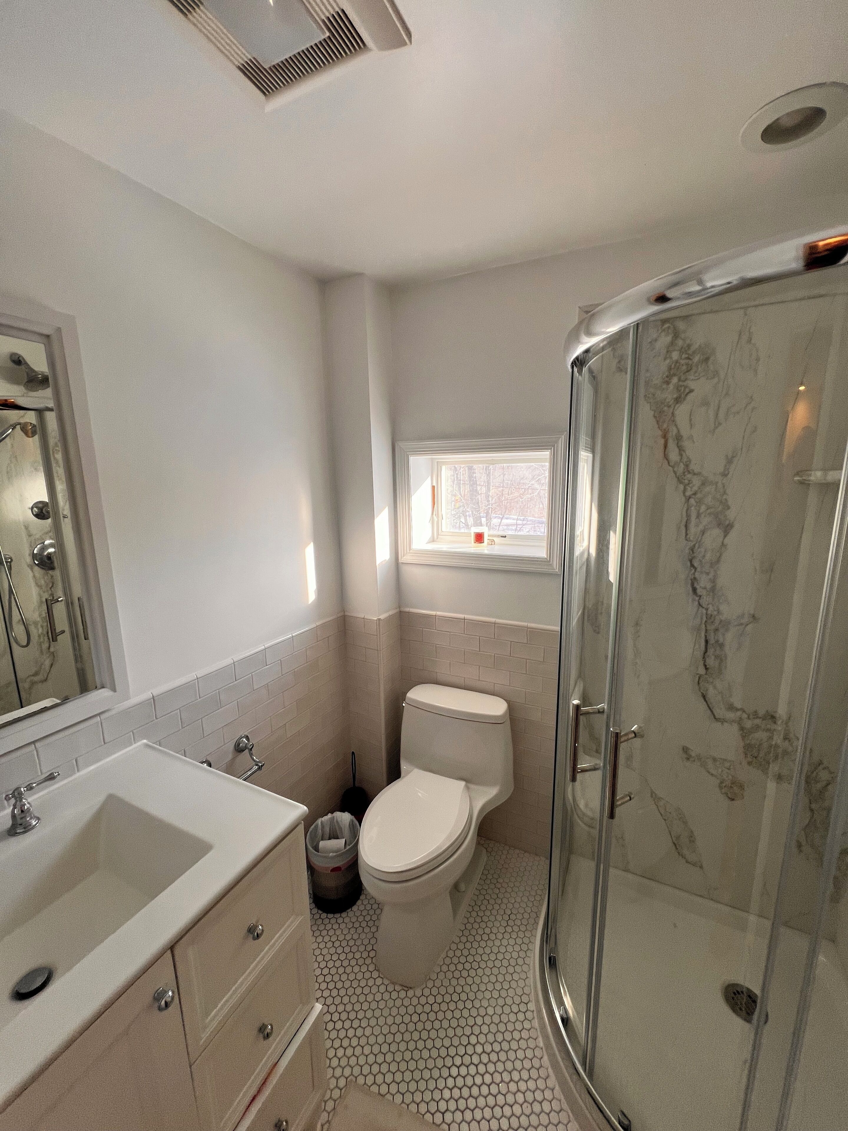 A bathroom with a toilet, sink, and shower.