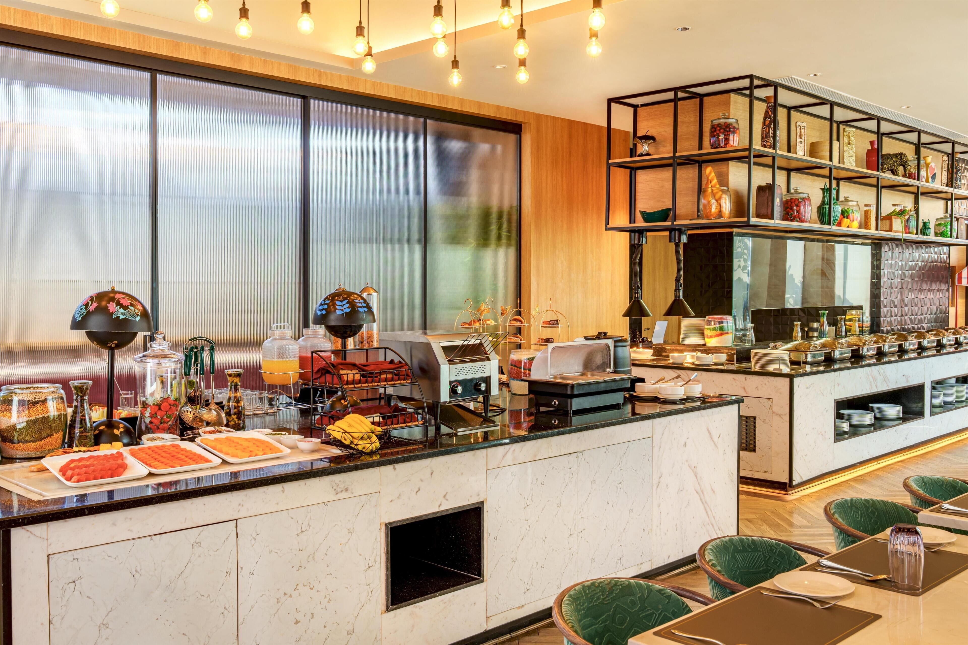 A breakfast bar with a variety of food items and a coffee station.