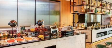 A breakfast bar with a variety of food items and a coffee station.