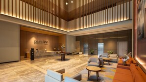 A modern lobby with a reception desk, seating areas, and a large artwork on the wall. - Park Inn By Radisson Jabalpur (Jabalpur)