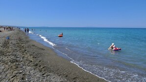 A beach with people walking and swimming, and a clear blue sky. - Staying in the Marina di Bibbona Apartments combines the convenience of feeling at home with the comfort of a holiday in a green setting, just steps from the sea and all the main amenities. With its pleasant atmosphere, <b>Marina di Bibbona</b> combines  (Marina di Bibbona)