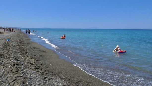 A beach with people walking and swimming, and a clear blue sky. - Staying in the Marina di Bibbona Apartments combines the convenience of feeling at home with the comfort of a holiday in a green setting, just steps from the sea and all the main amenities. With its pleasant atmosphere, <b>Marina di Bibbona</b> combines  (Marina di Bibbona)