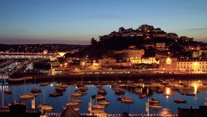 A harbor with boats, a castle on a hill, and buildings along the waterfront. - The Renoir Sea View Suite (Torquay)