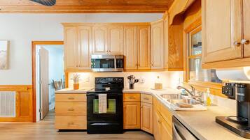 A modern kitchen with wooden cabinets, a stainless steel microwave, and a black oven.