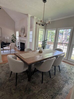 A dining area with a large wooden table, six chairs, and a chandelier. - Abbeys at  WestLake , Wonderful 3-bedroom house with AC in charming Martinez. (Martinez)