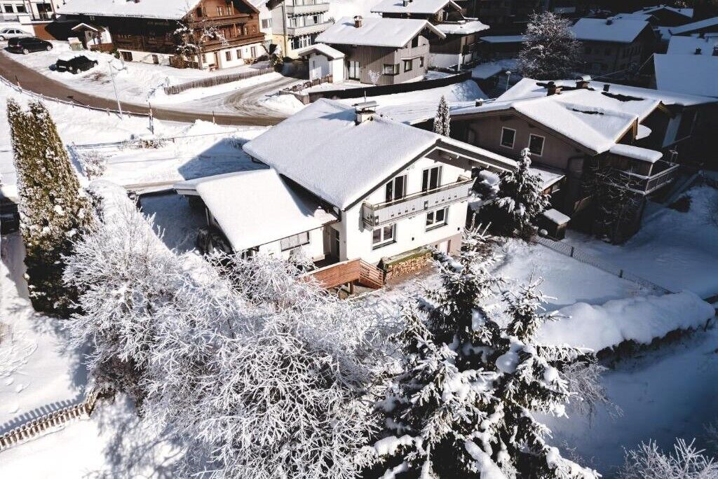 Un quartier résidentiel où les maisons et les arbres sont recouverts de neige.