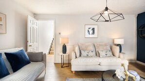 A modern living room with a white sofa, a blue couch, and a geometric pendant light. - 10 Mins Walk to The Oval The Kennington Retreat (London)