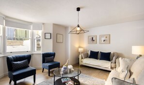 A living room with a sofa, two armchairs, a coffee table, and a hanging light fixture. - 10 Mins Walk to The Oval The Kennington Retreat (London)