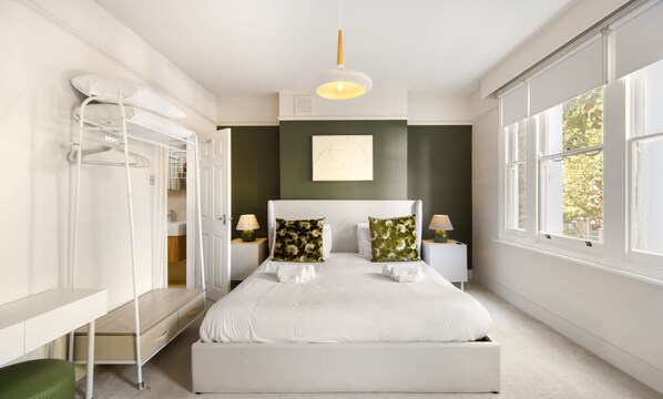 A bedroom with a bed, bedside tables, a wardrobe, and a window. - 10 Mins Walk to The Oval The Kennington Retreat (London)