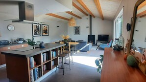 Et moderne køkken med en central ø, spiseplads og et hyggeligt siddeområde.