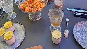 Een gedekte tafel met diverse gerechten, drankjes en bestek.