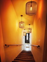Una escalera de madera con barandillas de metal que conduce a una puerta en la parte superior.
