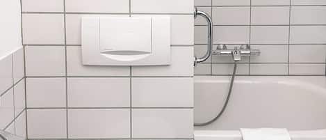 Une salle de bain moderne équipée de toilettes, d’une douche et d’une baignoire.