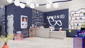 A modern reception area with a neon sign, a gaming console, and a variety of decorative items. - Symone Poitiers  (Poitiers)