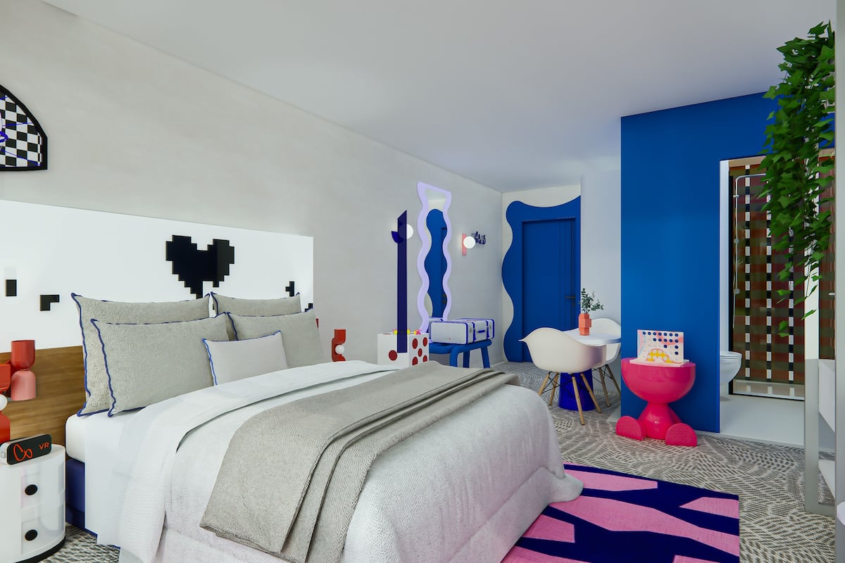 A modern bedroom with a bed, bedside tables, a vanity, and a mirror.
