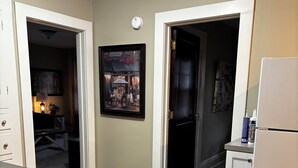 Un comedor con una mesa y sillas, un refrigerador, y una puerta que da a otra habitación.
