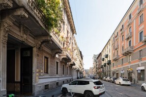 A street with parked cars, buildings with ornate facades, and a clear sky. - GuestHost - Modern mezzanine studio apartment of 35 m2, ideal for two people, located on the raised ground floor of a typical Milanese building (stairs to access the apartment).The property is located a stone's throw from the M1 Lima stop in a strategi (Milan)