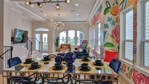 Un espace repas avec une table en verre, des chaises noires et des bols décoratifs.