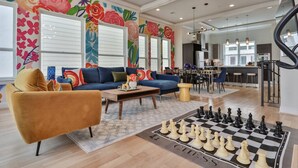 Un salon comprenant un canapé, un fauteuil, une table basse et un jeu d’échecs.