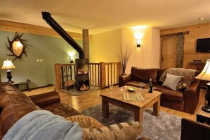 A cozy living room with a fireplace, leather sofas, and a wooden floor. - Ormes Sainte Foy Chalet (Sainte-Foy-Tarentaise)