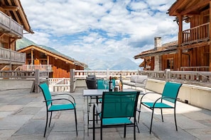A terrace with a table and chairs, overlooking a mountainous landscape. - Ormes Sainte Foy Chalet (Sainte-Foy-Tarentaise)