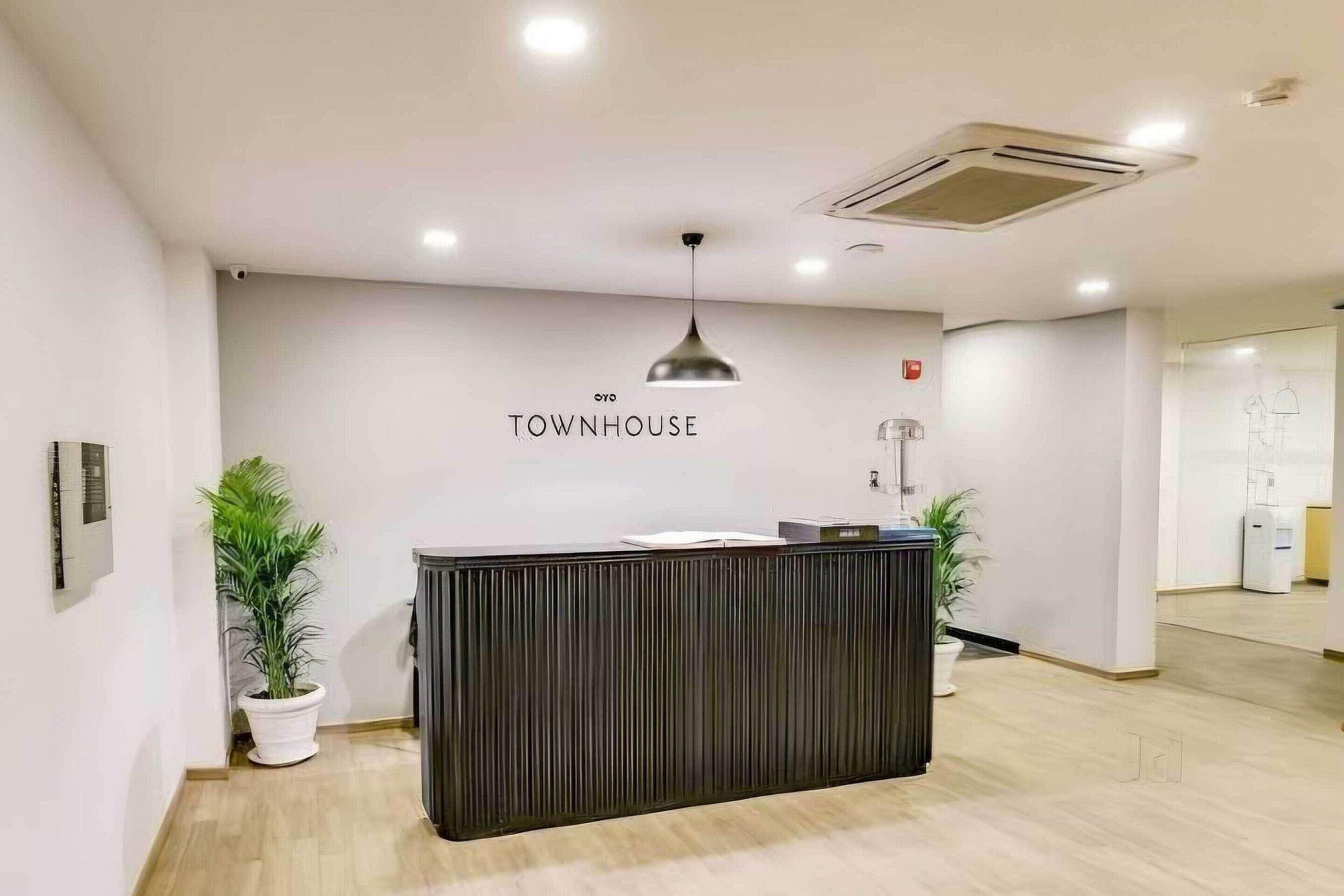 Ein Empfangstresen mit einem Schild, das "TOWNHOUSE" zeigt, und einem modernen Innendesign.