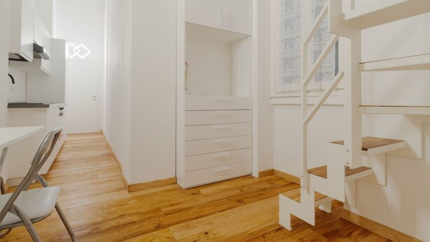 A modern interior with a wooden floor, white cabinetry, a staircase, and a view through a window. - GuestHost - Modern mezzanine studio apartment of 30 m2, ideal for two people, located on the raised ground floor of a typical Milanese building (stairs to access the apartment).The property is located a stone's throw from the M1 Lima stop in a strategi (Milan)